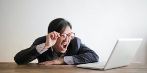 yelling formal man watching news on laptop